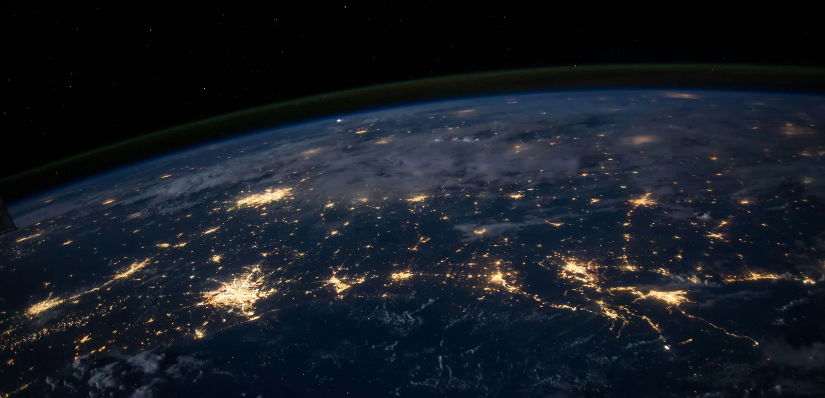 Earth at night from space, golden city lights and glowing connection arcs over the Americas